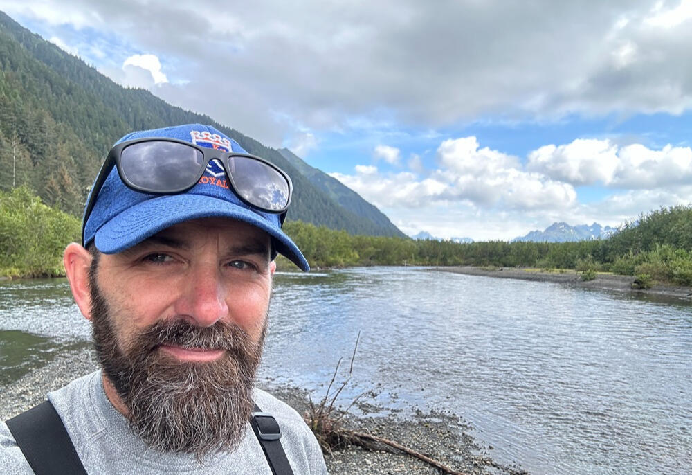 Dion with river, forest, and mountains in background